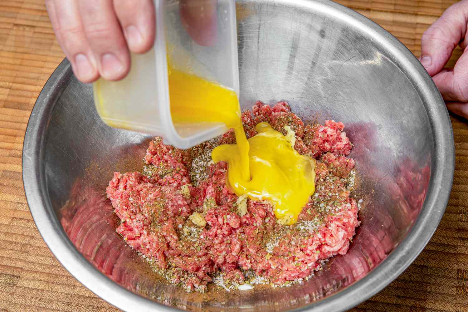 Whisked Egg Added to Bowl of Greek Meatball Ingredients (Ground Beef and Seasoning)