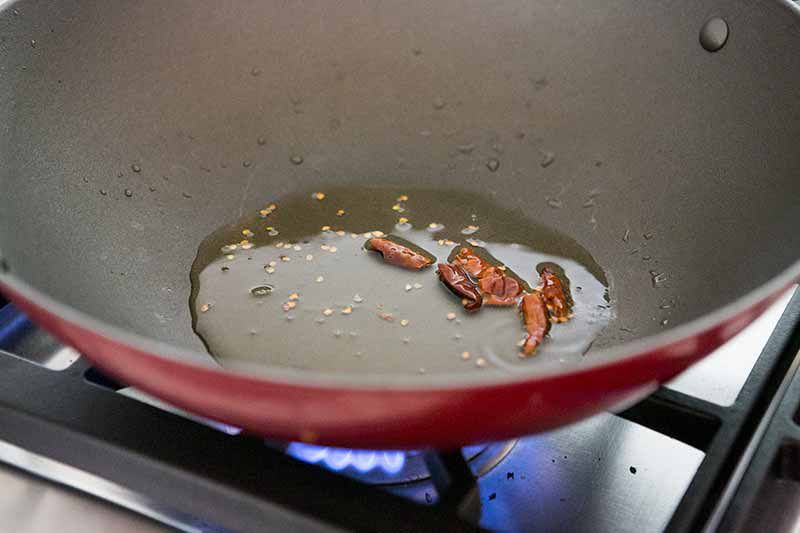Infusing stir-fry oil with chile in a wok