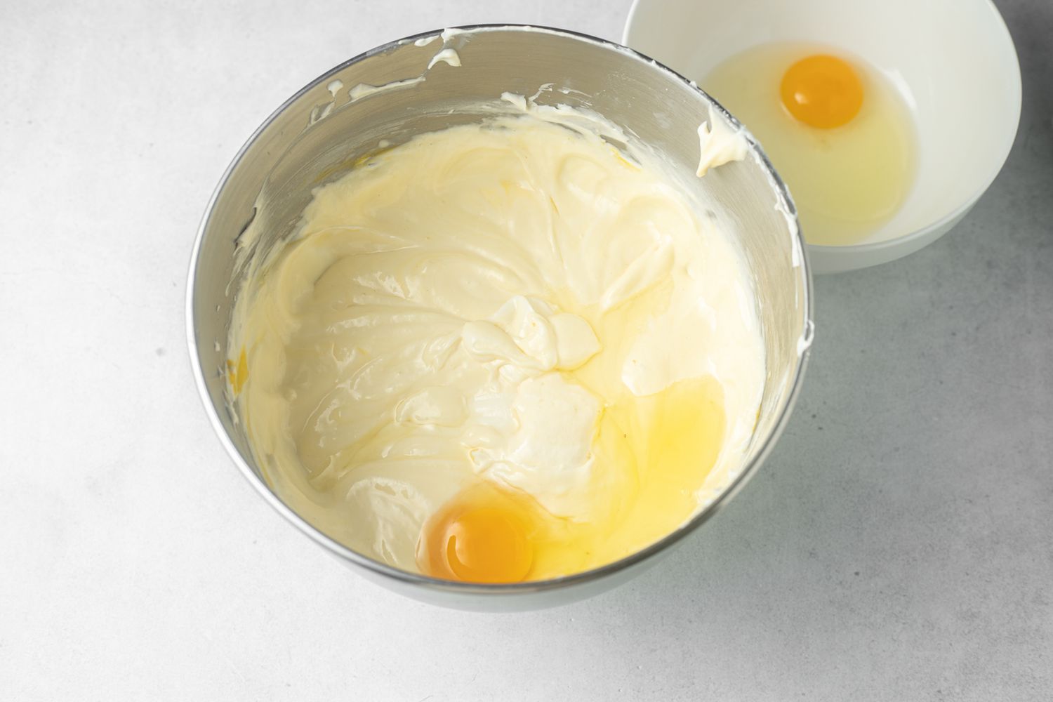 Making the feeling for pumpkin cheesecake in a metal bowl.