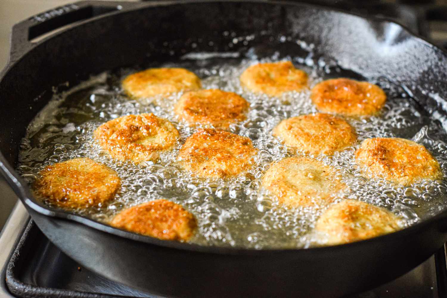 Frying green tomatoes in a cast iron skillet.