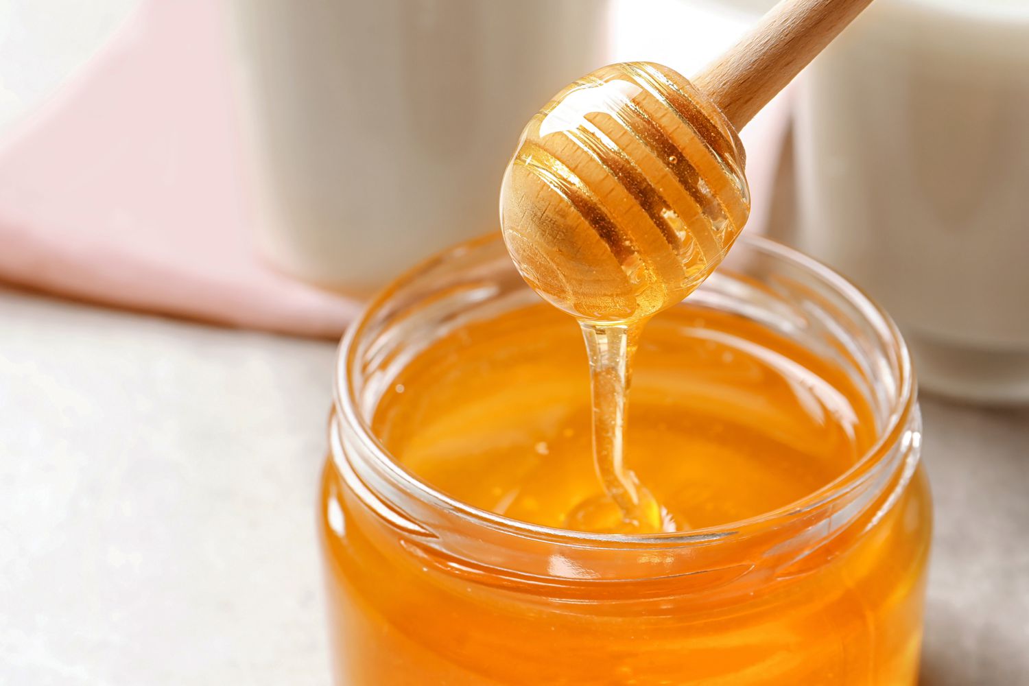 Honey jar with honey dripped from honey dipper