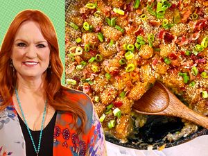 Ree Drummond next to a dish of cowboy casserole with a wooden spoon