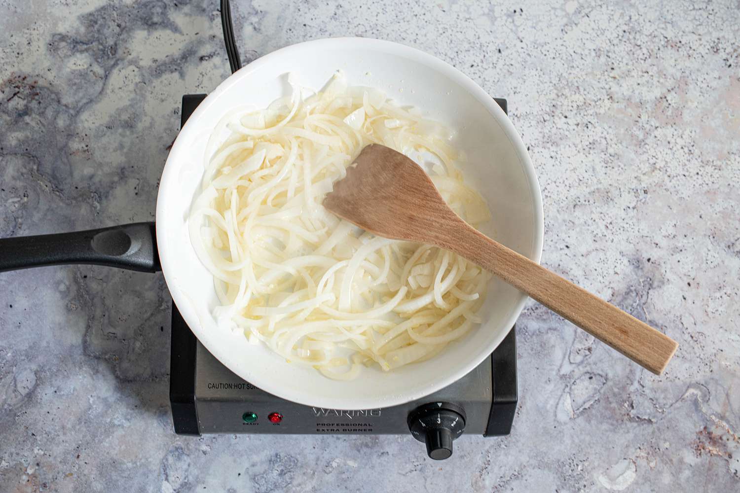 Sliced Onions Cooking on a Skillet on a Portable Burner 