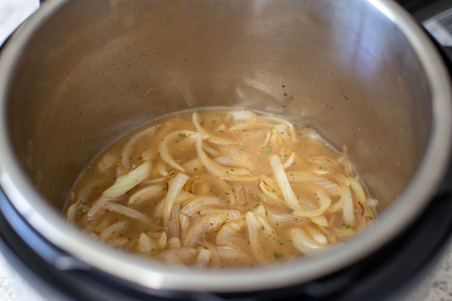 Chicken broth and sauteed onions in an instant pot to make instant pot turkey breasts.