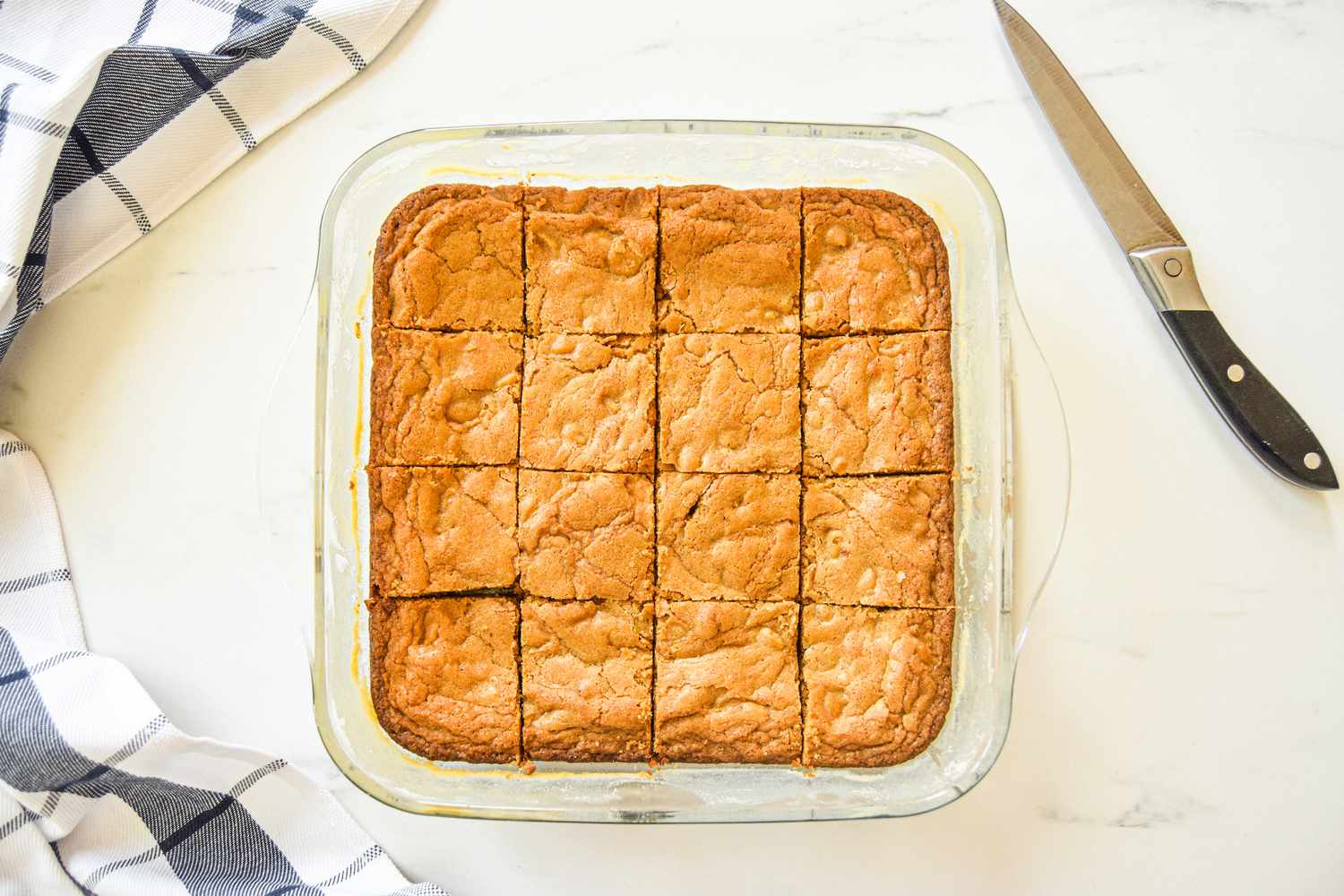 Overhead view of a pan of blondies cut into squares.