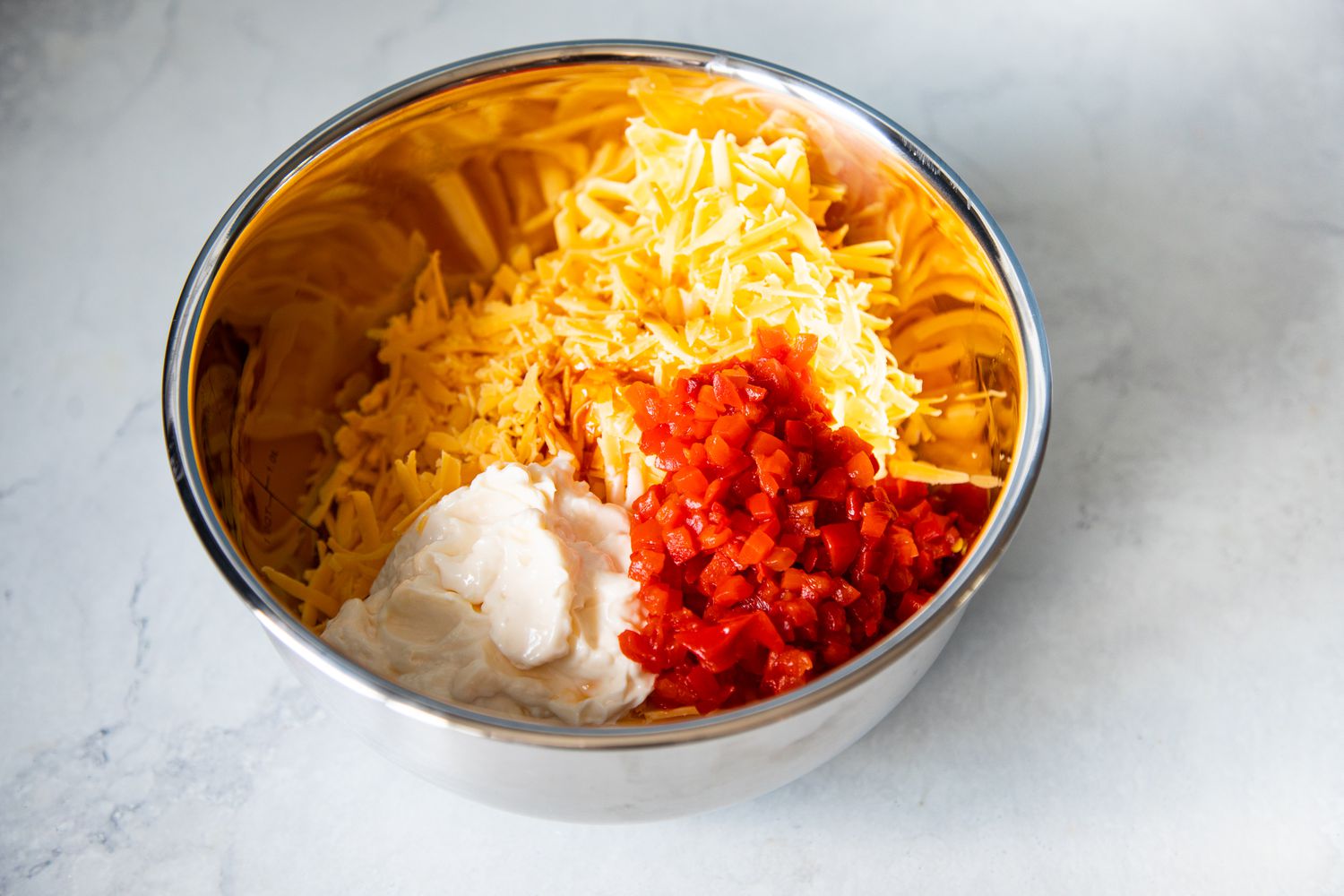 Bowl of Cheddar Cheese, Mayonnaise, and Pimento Peppers for Pimento Cheese Recipe