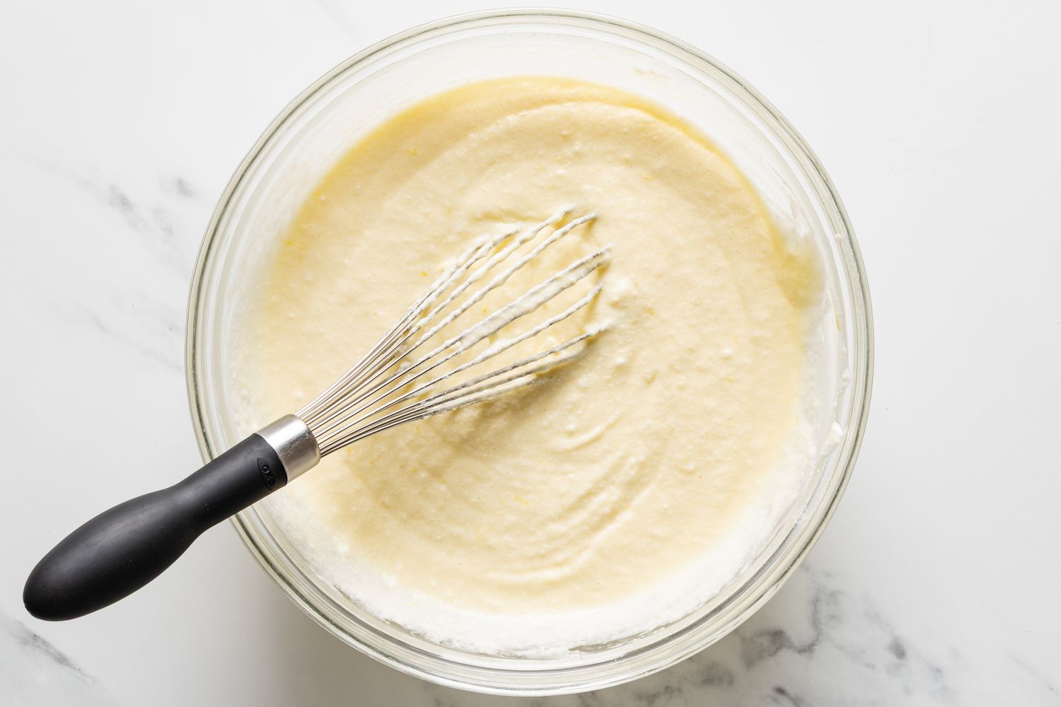 Overhead view of a whisk mixing the filling for Magic Lemon Pie recipe