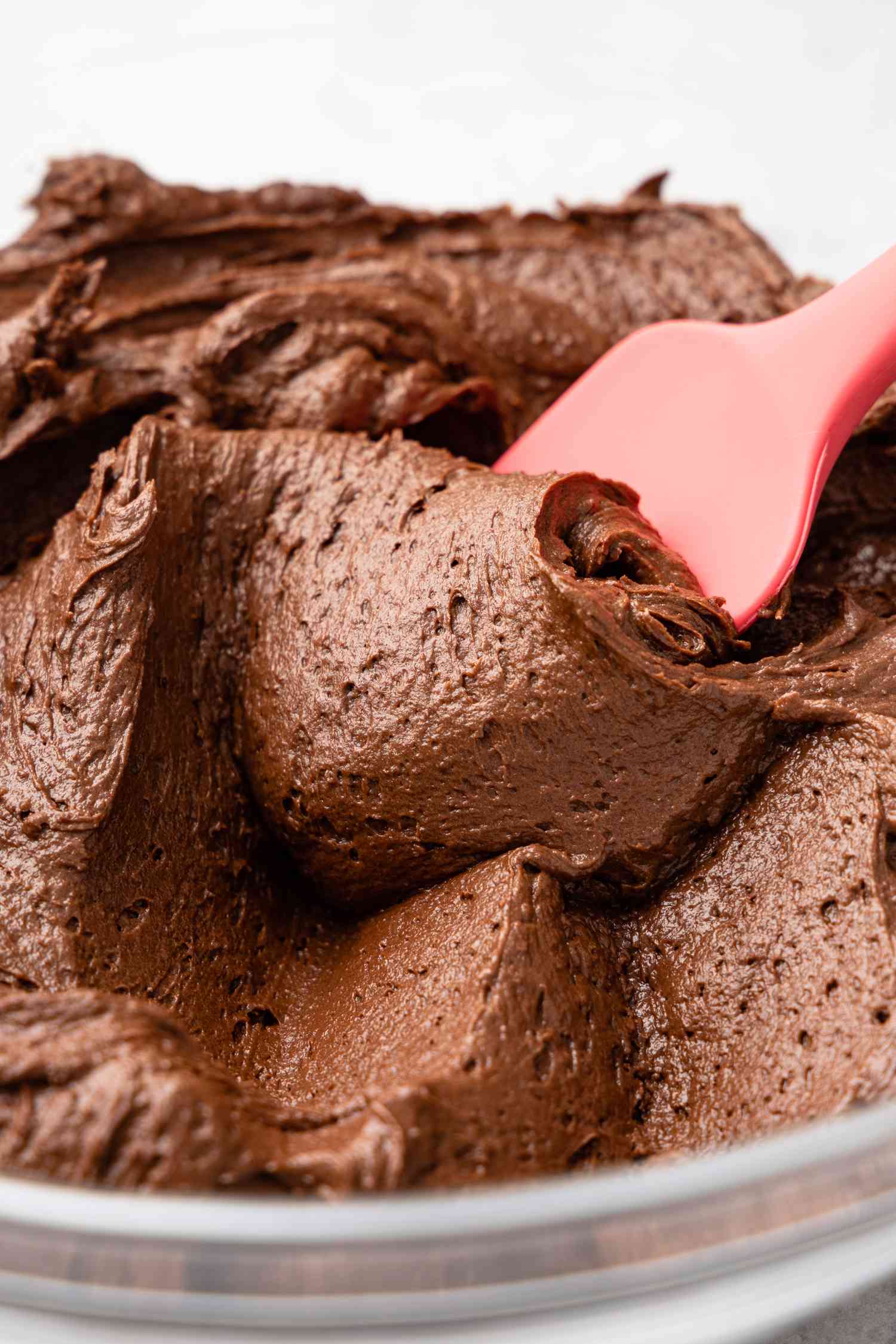 Bowl of Easy Chocolate Buttercream Frosting With a Rubber Spatula