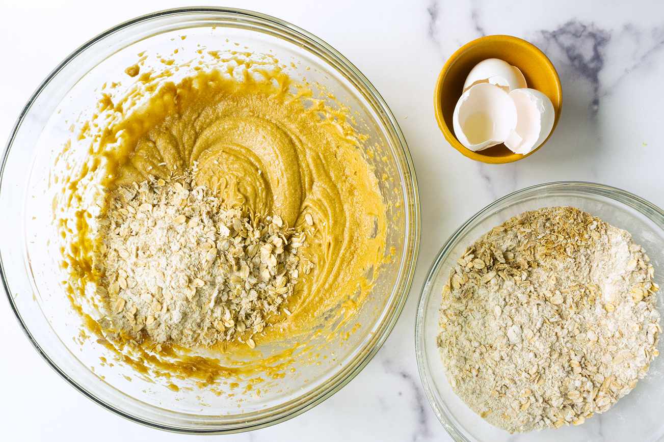 Ingredients and batter for breakfast cookies including dry oats and shells in a bowl