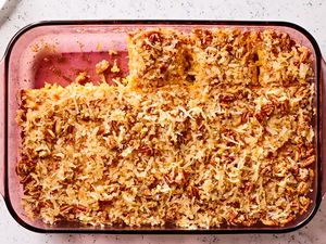 Overhead view of a glass baking dish of pineapple coconut cake with two slices removed