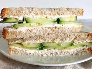 1-minute cucumber sandwich sliced in half and on a plate