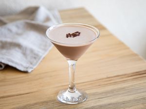 A chocolate martini in a martini glass, garnished with chocolate shavings