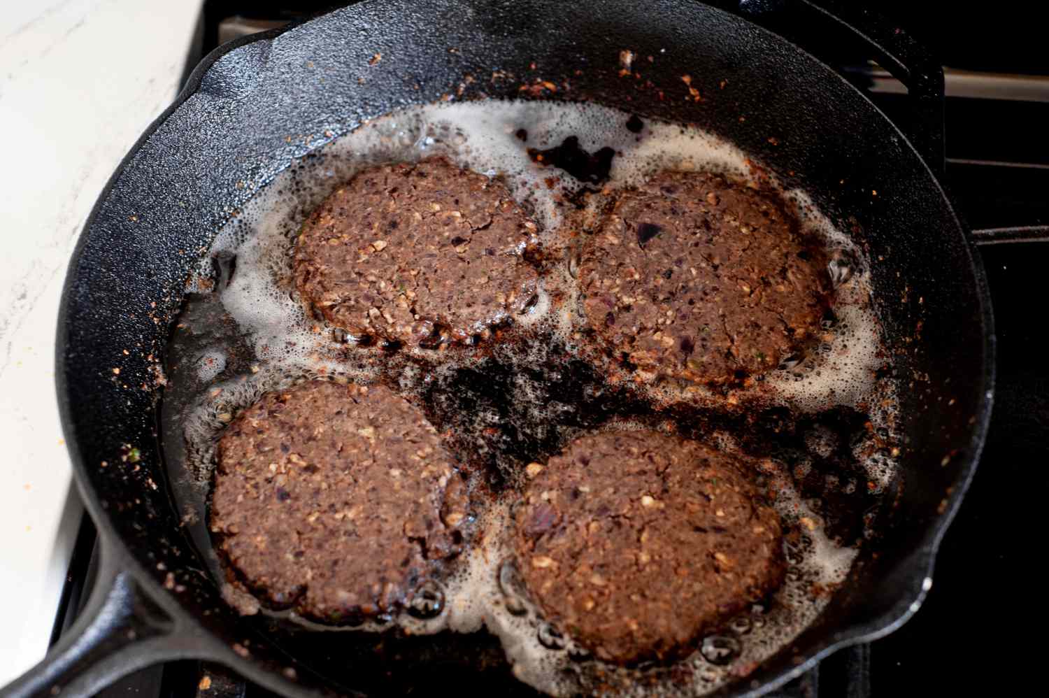 Black Bean Smash Burger Frying in Cast Iron Skillet 