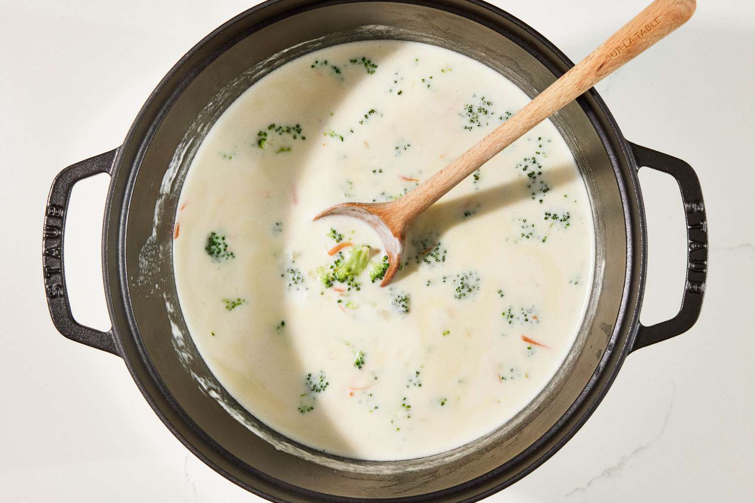 Water and cream added to Dutch oven to create the soup base for copycat Panera broccoli cheddar soup recipe