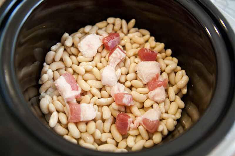Layering beans and salt pork for crock pot baked beans