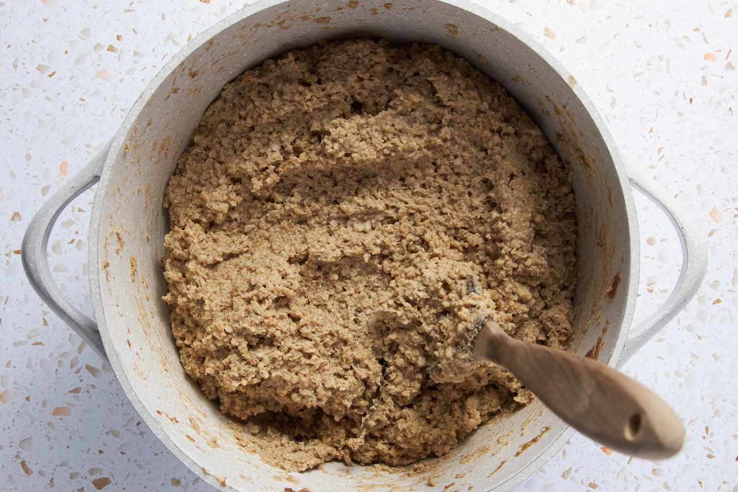 Goetta Mixture in a Dutch Oven With a Spoon, Consistency Thicker (No Liquid Leftover)