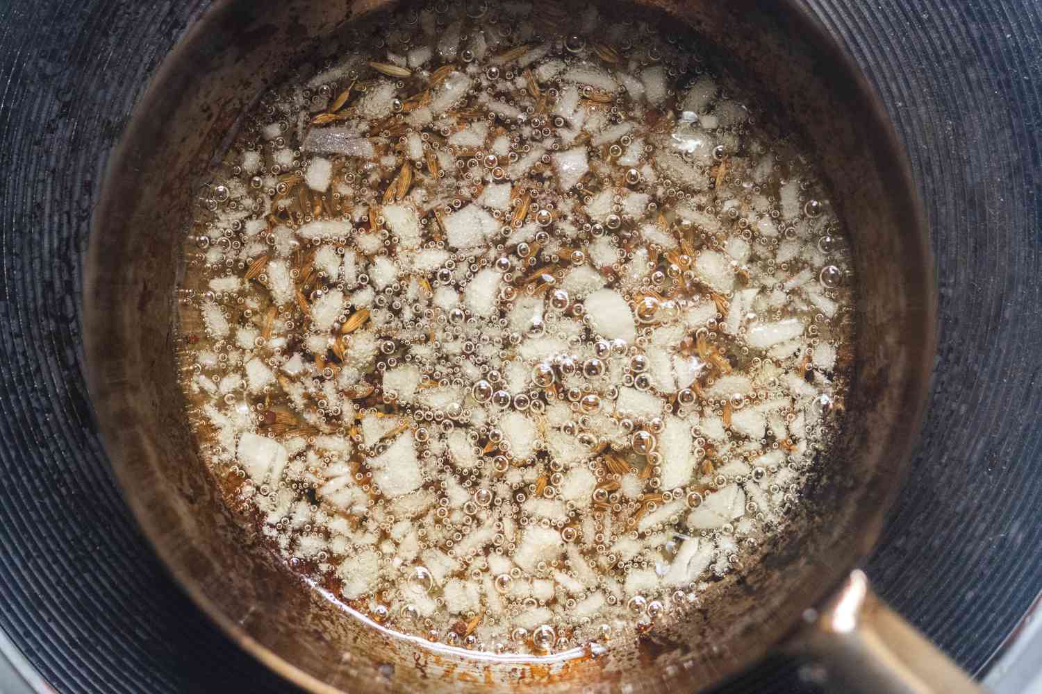 Alliums and whole spices added to oil for how to bloom spices