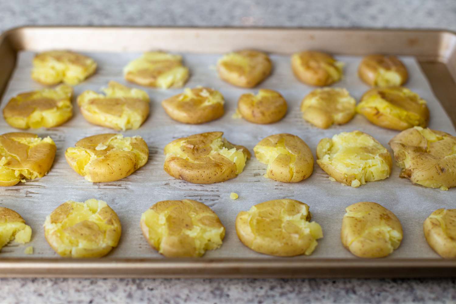 Smashed potatoes on a baking sheet to make cream cheese and smoked salmon crispy potatoes.