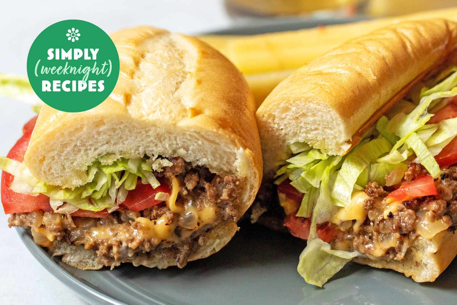 Two sandwiches filled with ground meat, lettuce, and tomato on a plate, with a Simply Weeknight Recipes logo