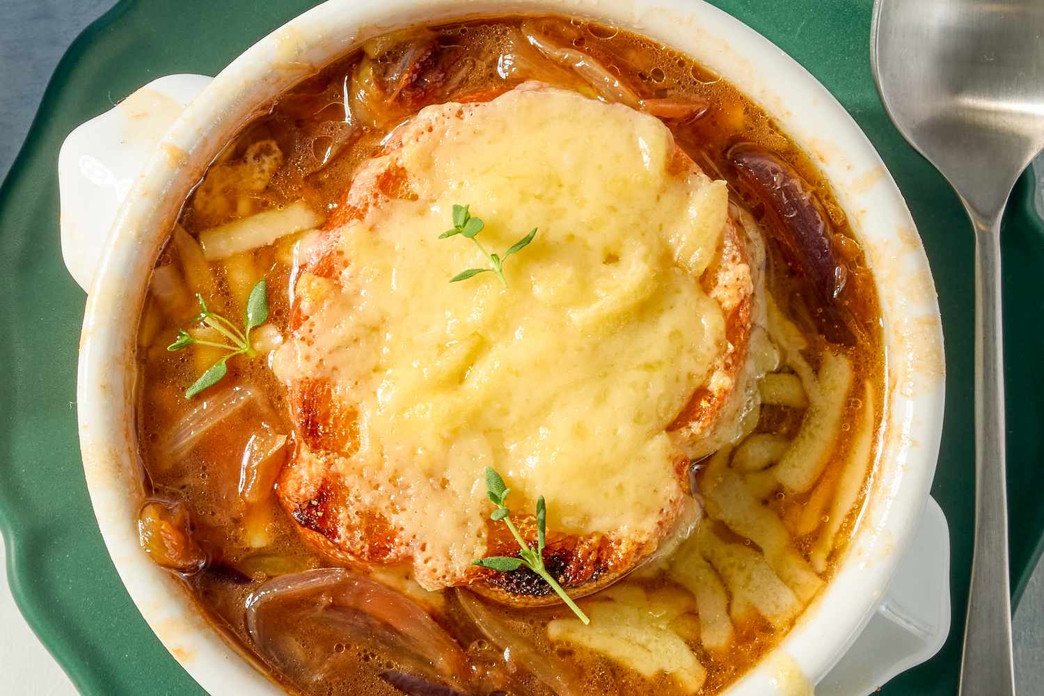 French onion soup in a bowl with melted cheese and a bread topping