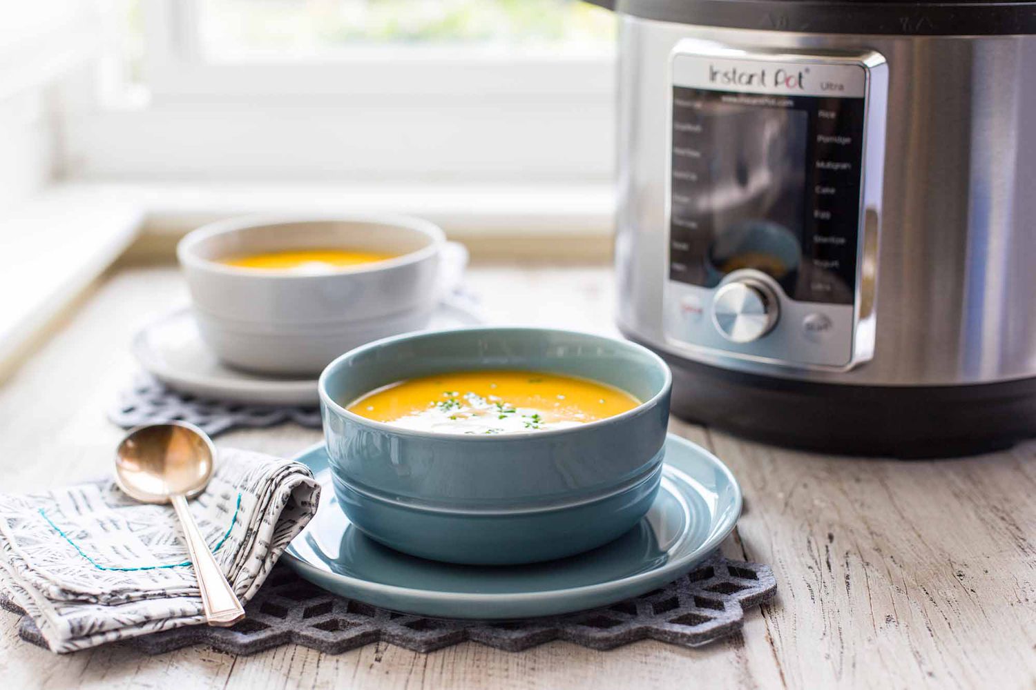 2 Bowls of Butternut Squash on Table next to Instant Pot