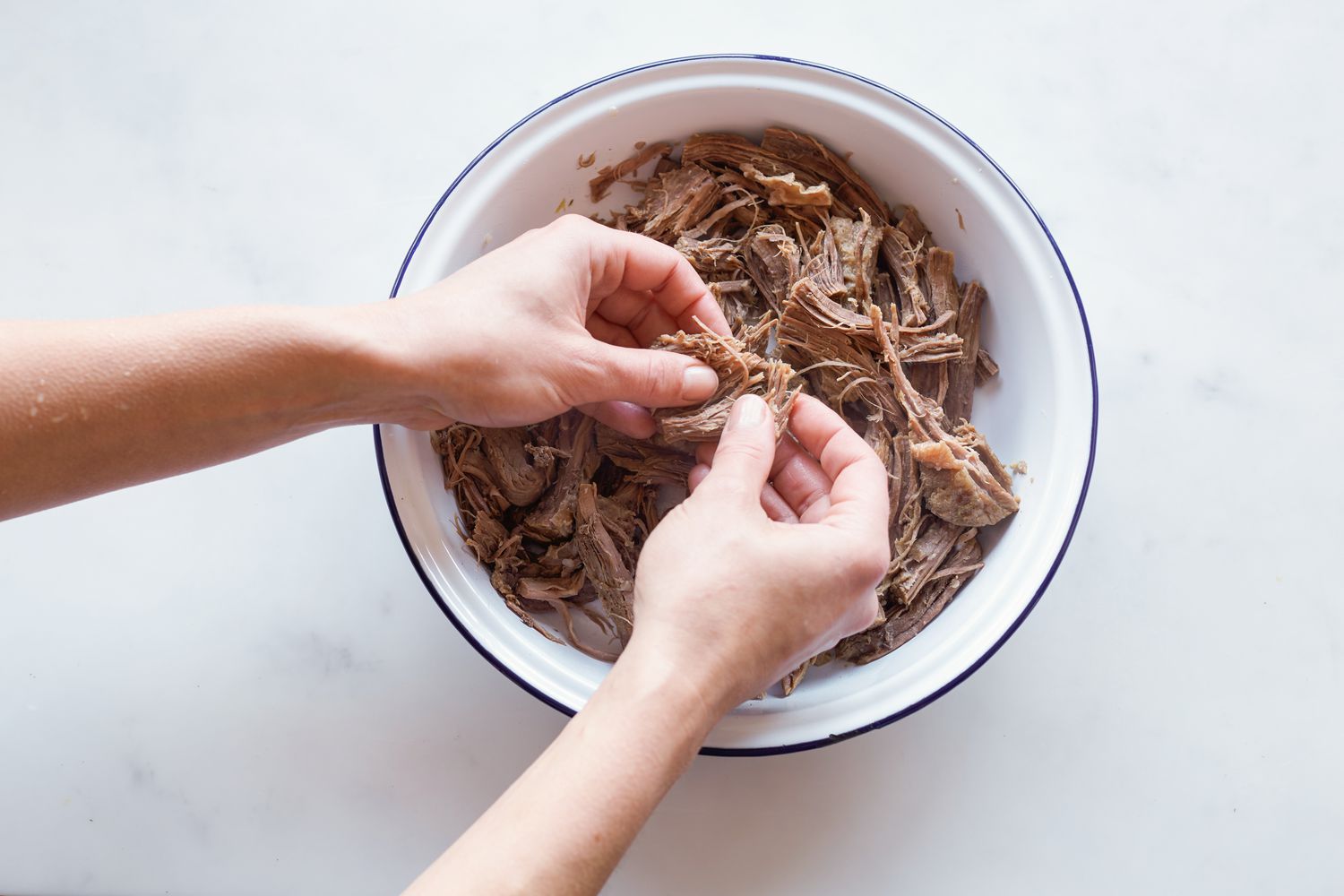 Shredding brisket for rice cake soup.