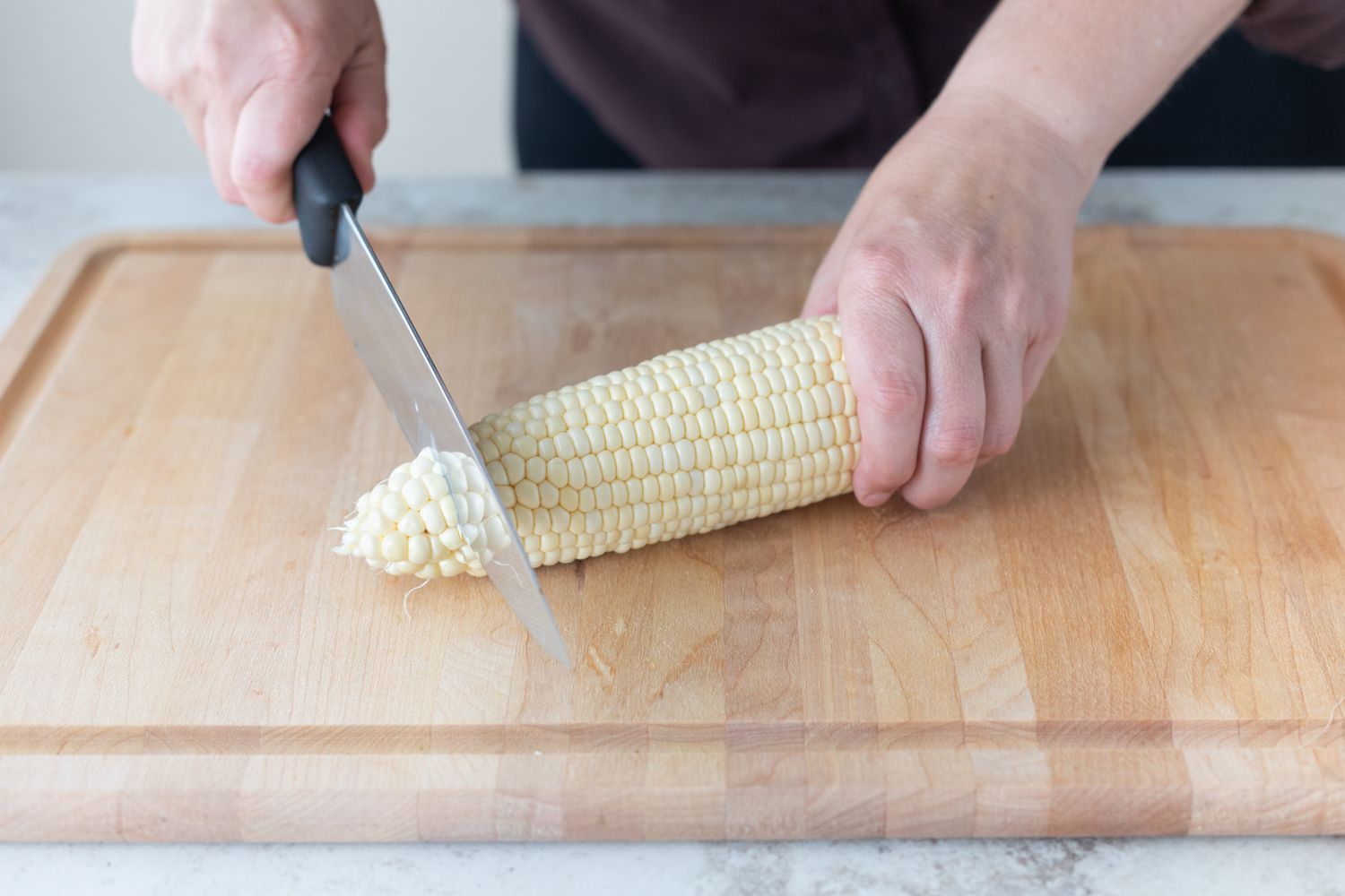 Trimming off the ends of an ear of corn