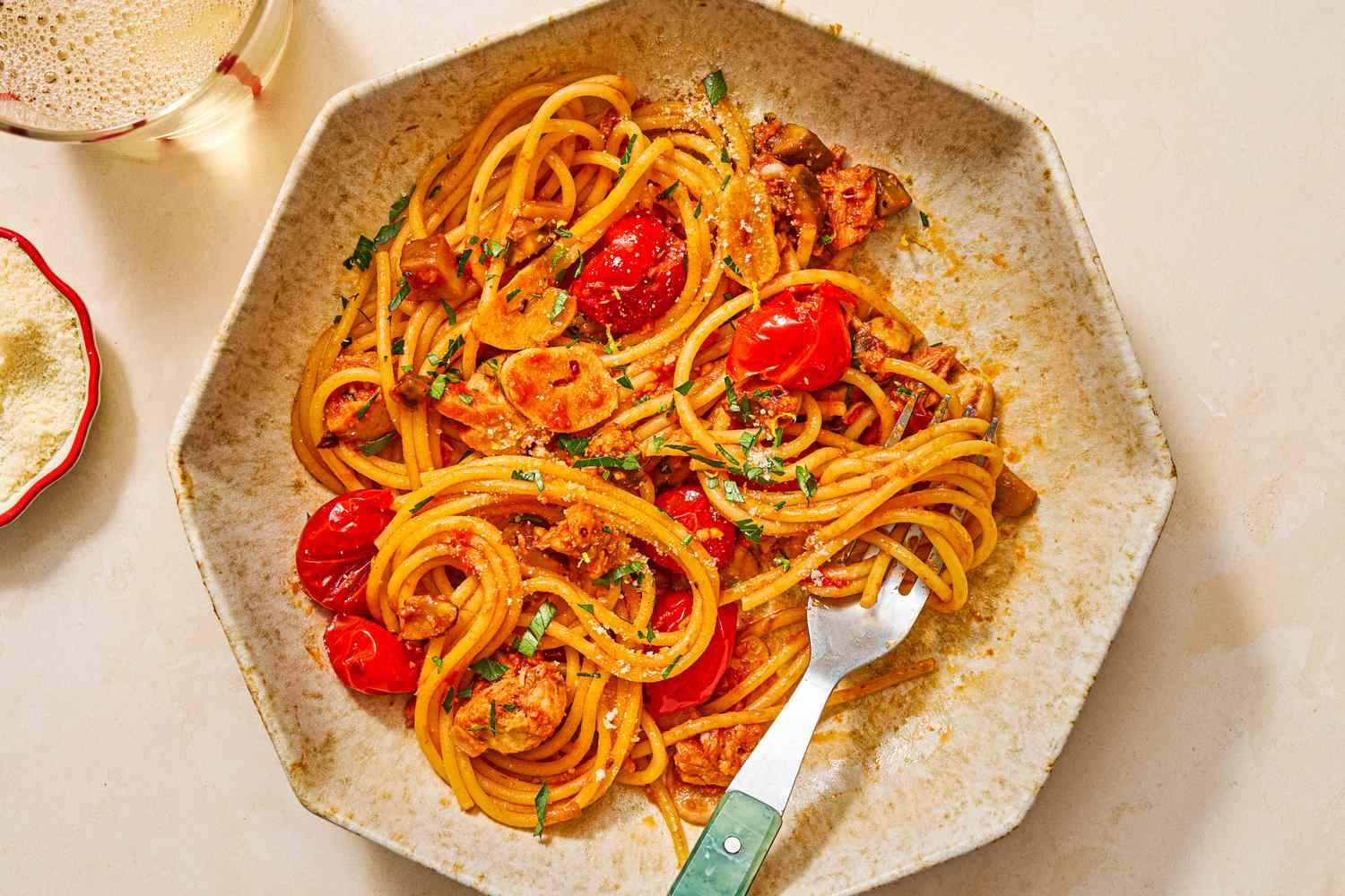 Plate of spaghetti alla carrettiera with cherry tomatoes and herbs on a table