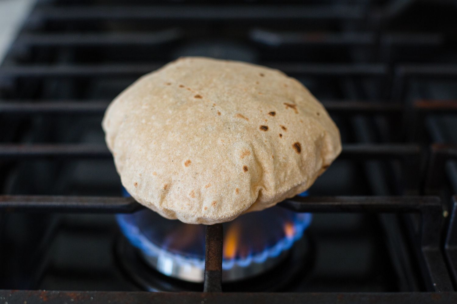 Showing how to make roti on the stovetop.