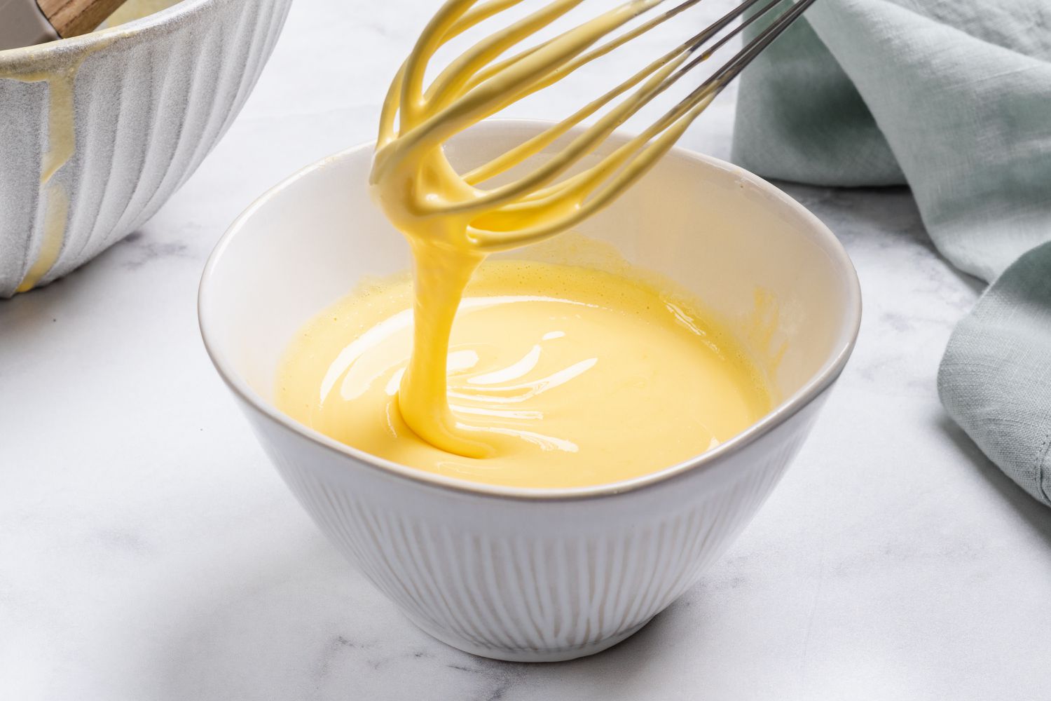 Whisking the eggs to add to the custard to make a vanilla ice cream recipe