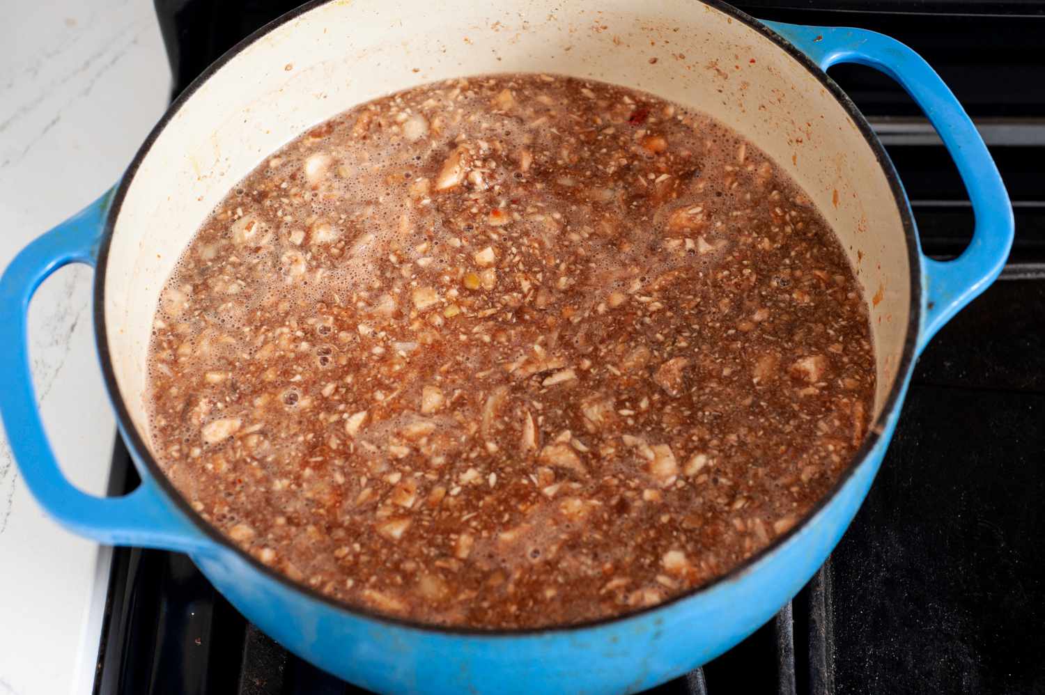 Minced Mushrooms for Vegan Cincinnati Chili Boiling in a Dutch Oven over the Stove