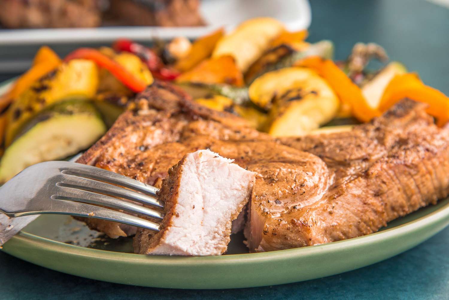 Pork Chop on Plate with Piece on a Fork