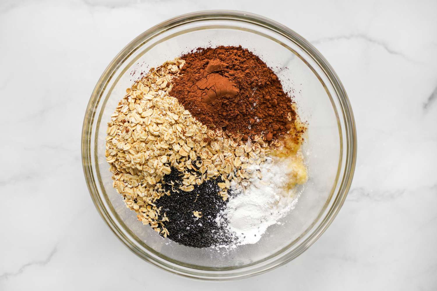 Bowl of Vegan Brownie Baked Oatmeal Dry Ingredients (Oats, Cocoa Powder, Chia Seeds, Espresso Powder, etc) 