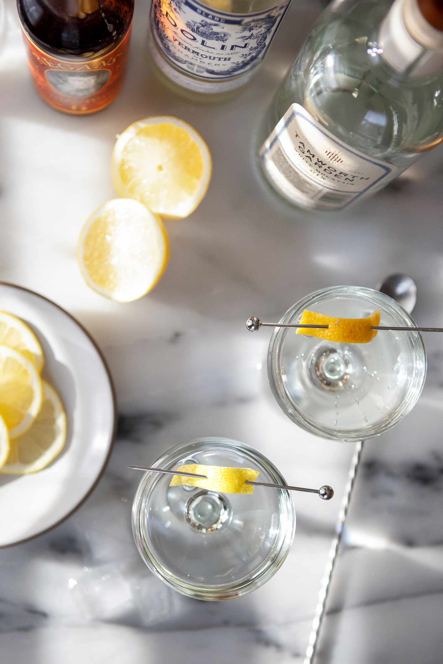 Overhead view of Gin Martini Cocktails on a table with lemon, vermouth, and gin.