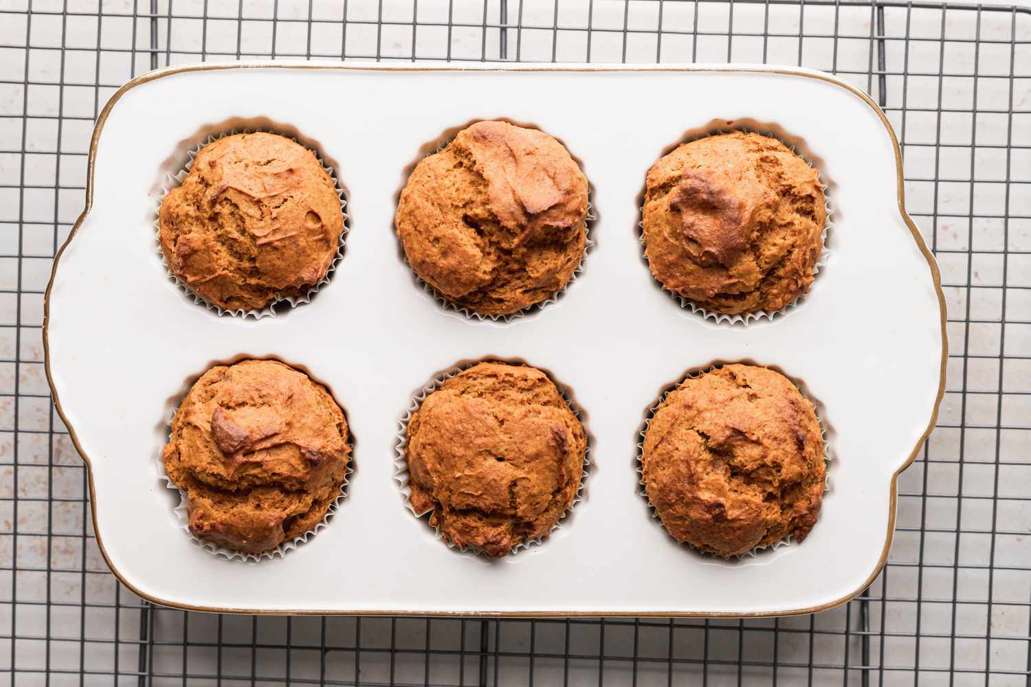 Quick and easy pumpkin muffins cooling on a rack.