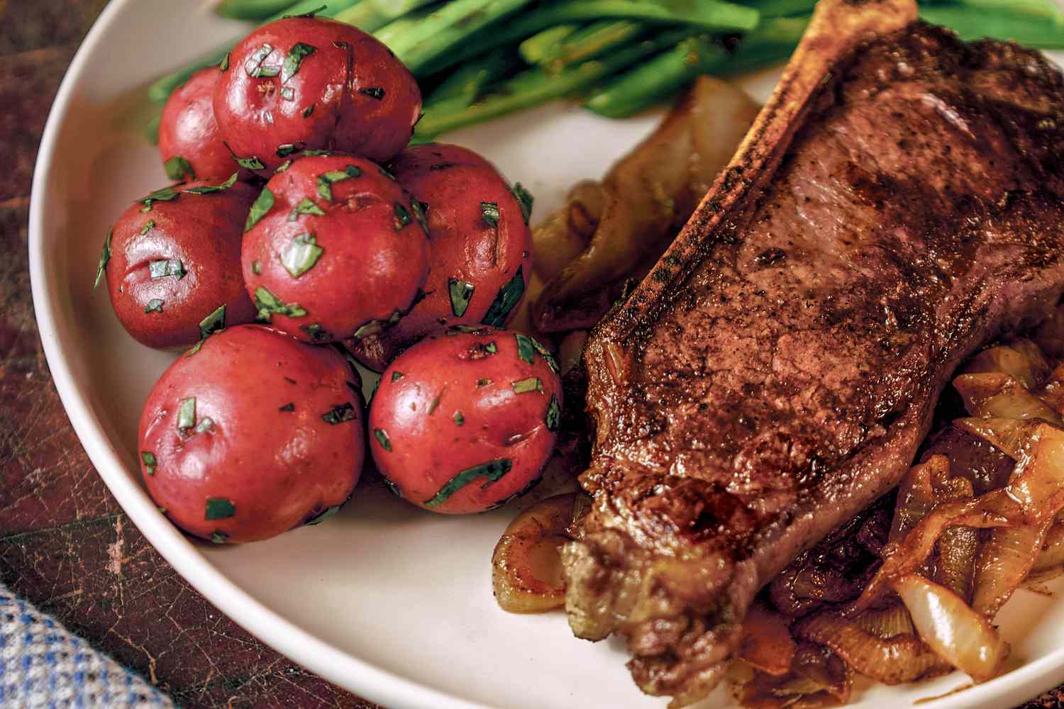 Steak with sweet onions served with red potatoes and green beans
