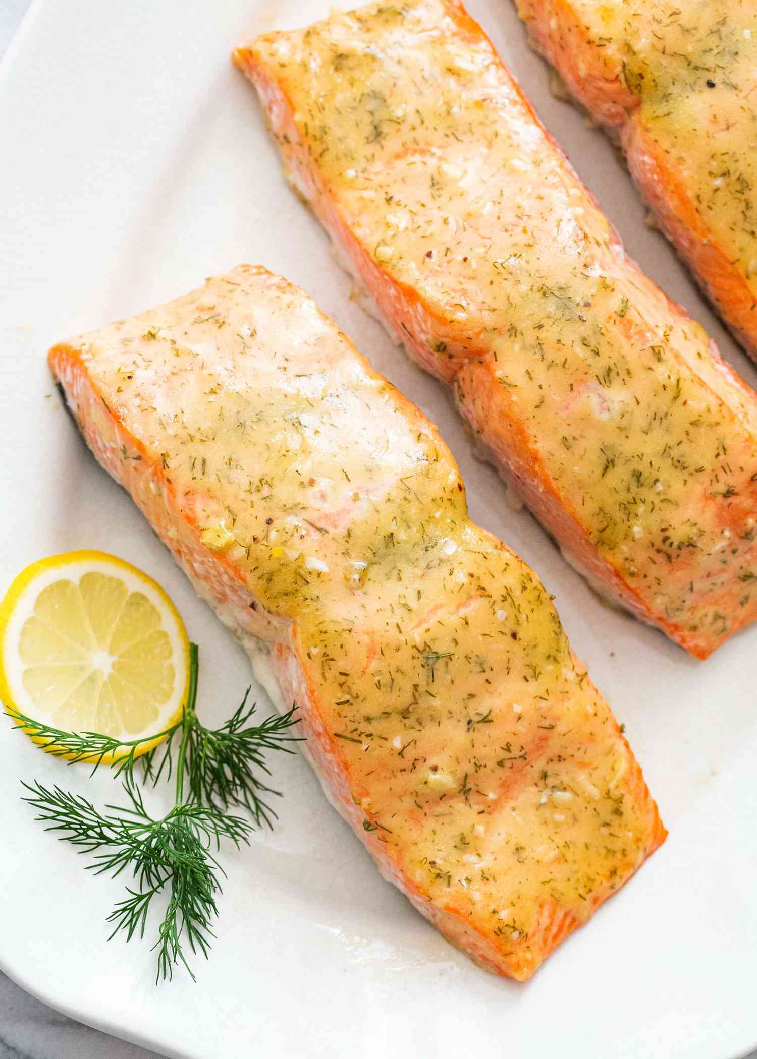 Baked honey mustard salmon on a platter with lemon garnish.