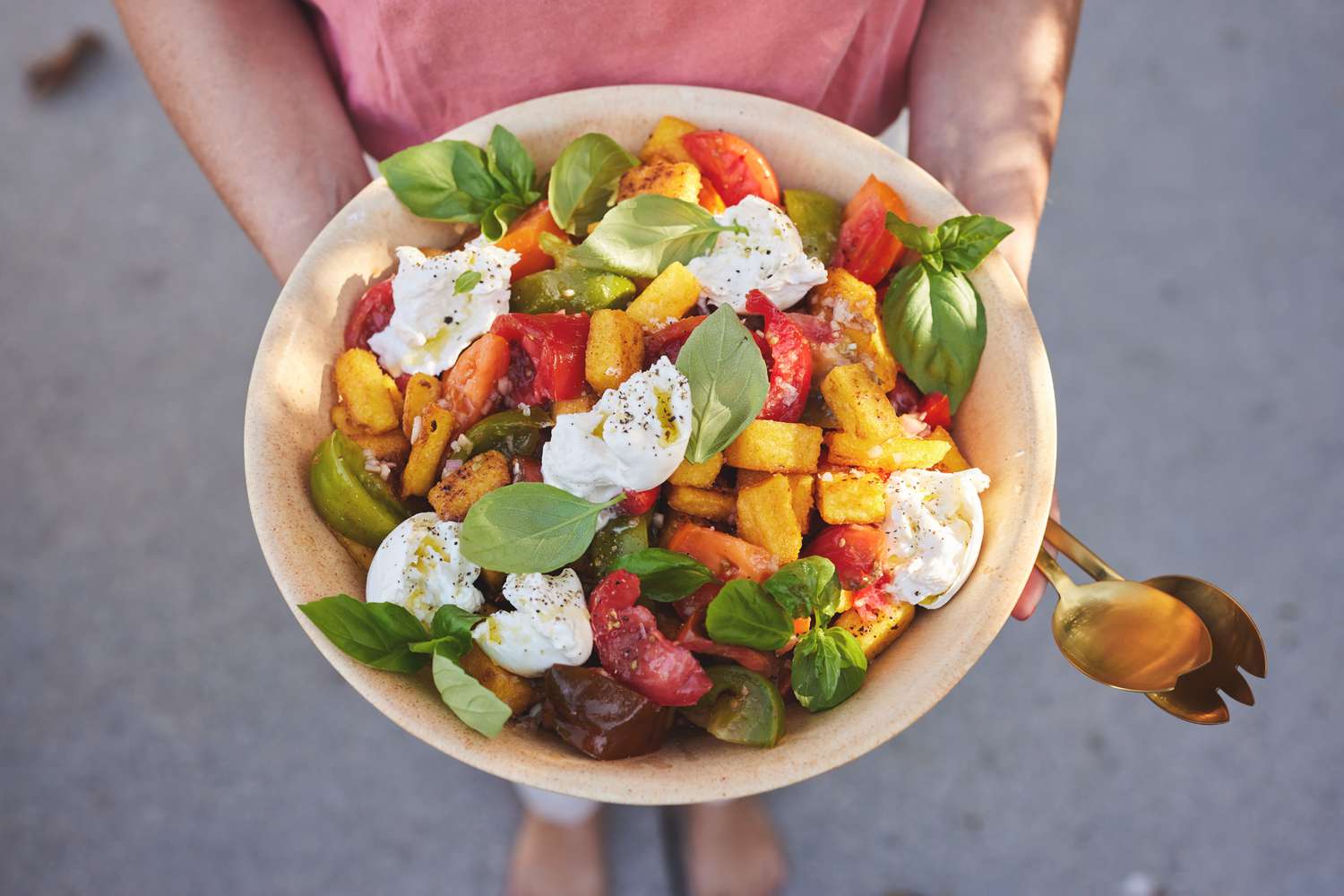 Someone Holding a Bowl of Fried Polenta Panzanella with Tomato, Basil, and Burrata and Utensils