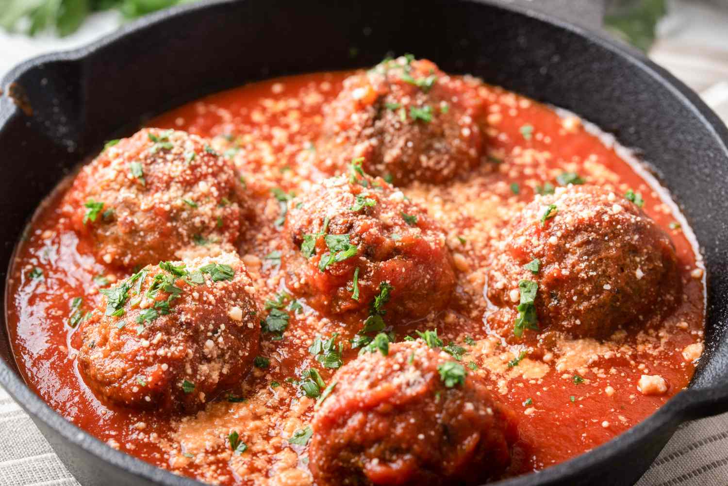 Meatballs with tomato sauce in cast iron skillet