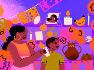 Dia de Muertos altar with a young boy and woman standing in front of it