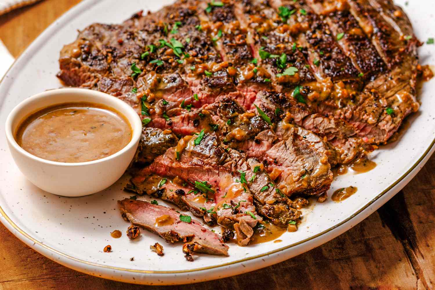 Overhead view of easy steak au poivre on a platter on a wooden tabletop