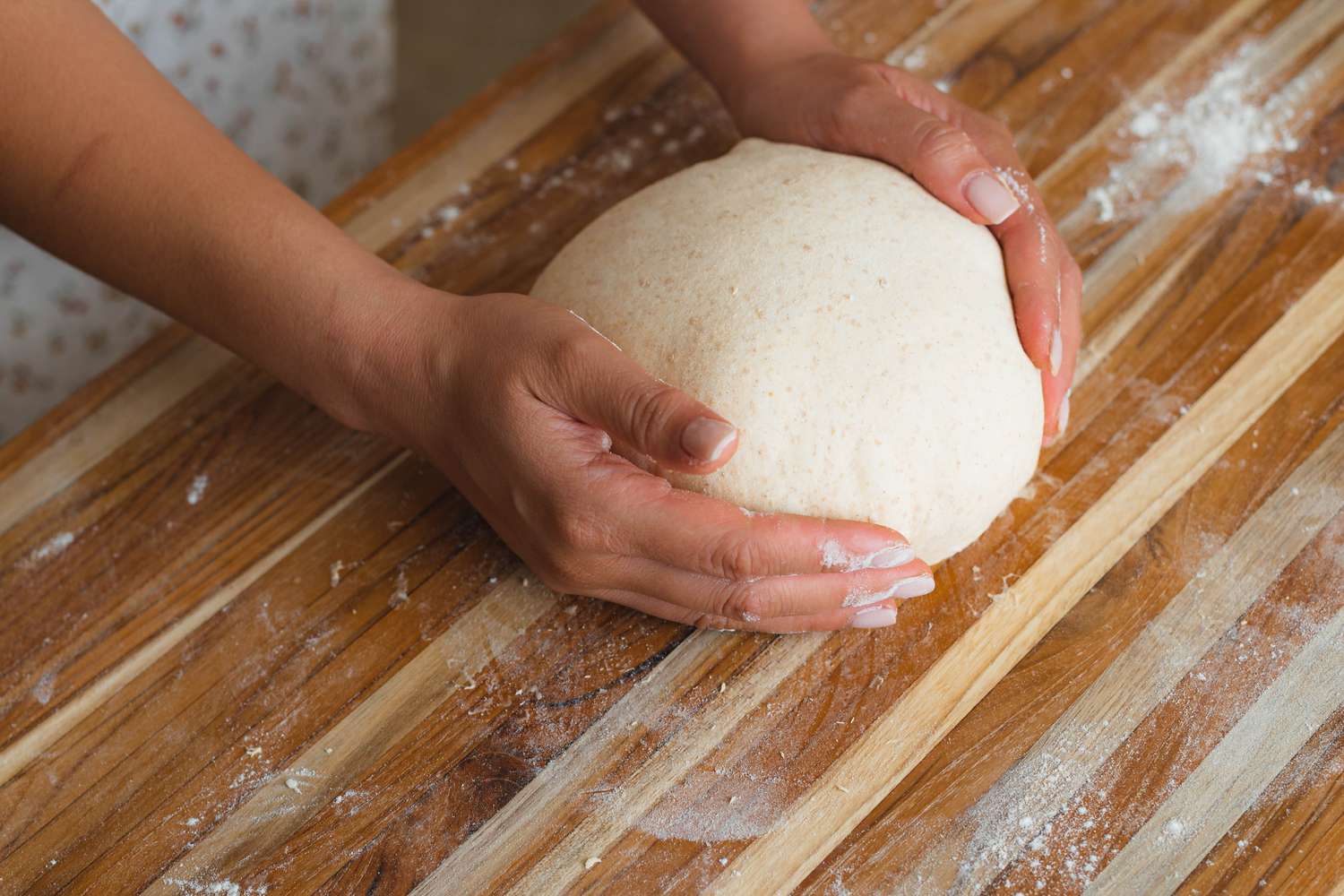 Shaping dough on a counter to make spiced sourdough bread shaped like a pumpkin