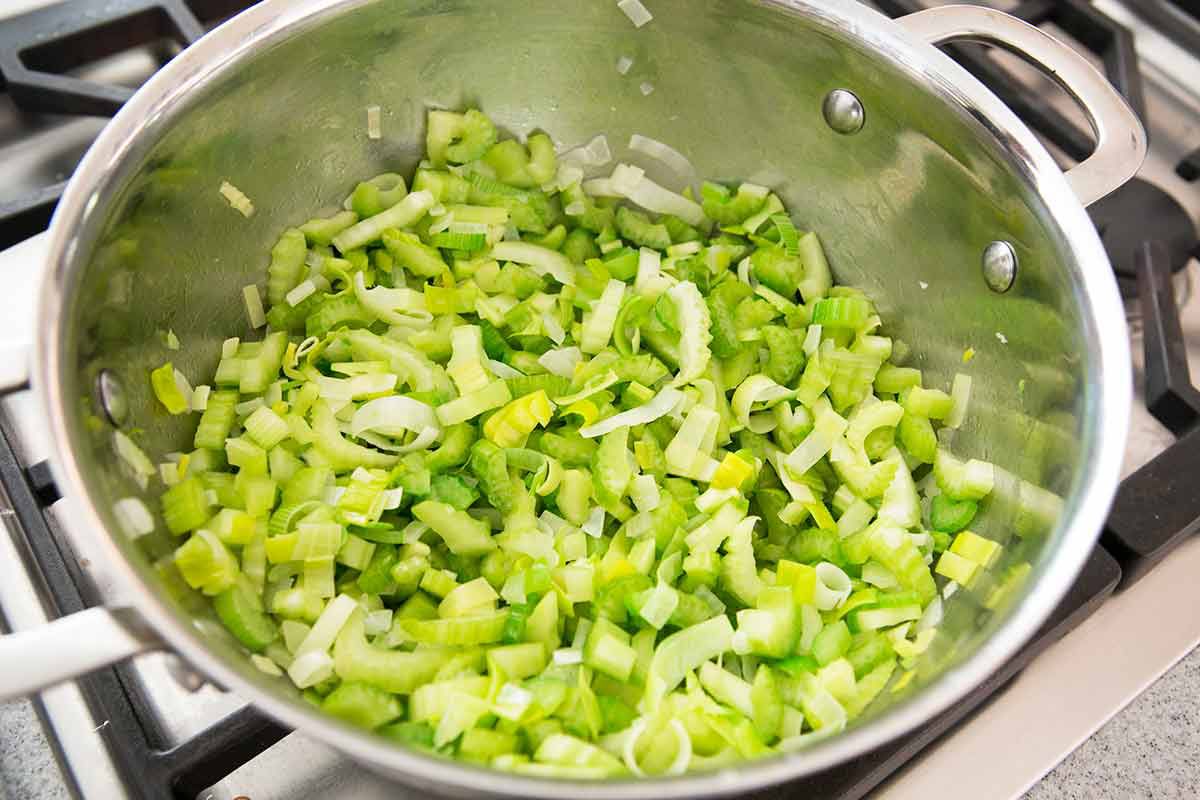 Sautéing chopped celery in a pot