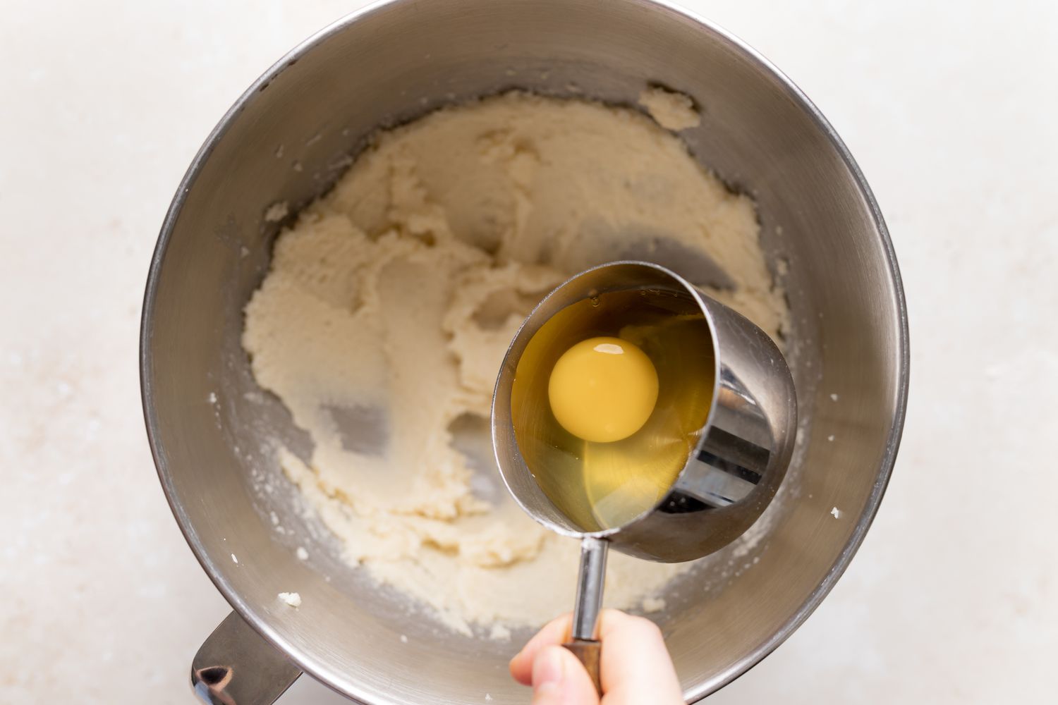 Adding eggs to the batter for a butter cake with fresh cherries.