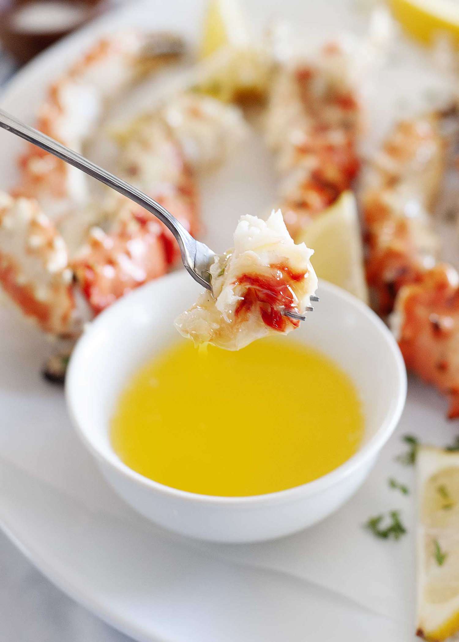 Dipping king crab legs in melted butter.