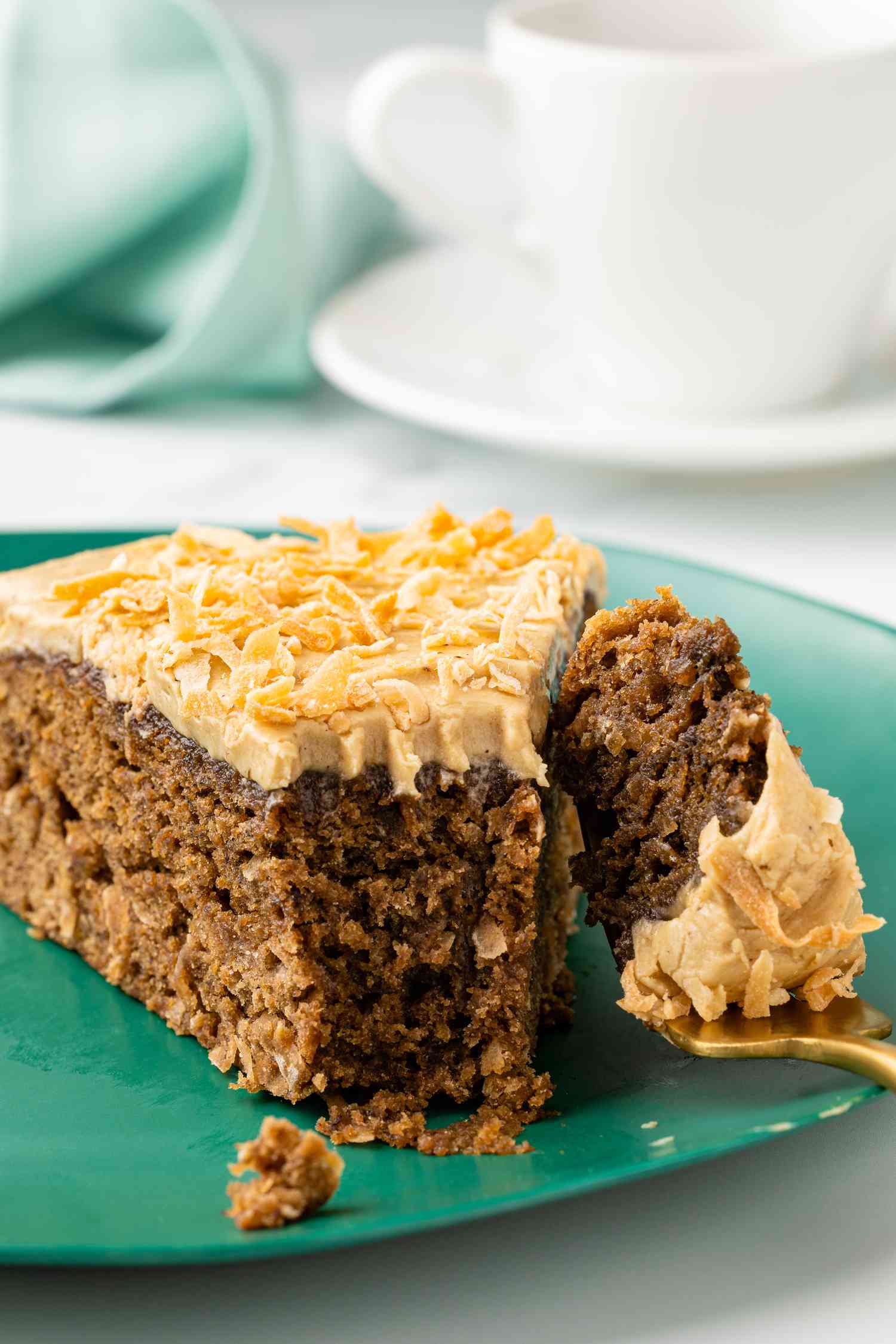 Coffee Coconut Banana Bread Cake on a Cake Platter With a Cut Slice Being Removed Using a Pie Server