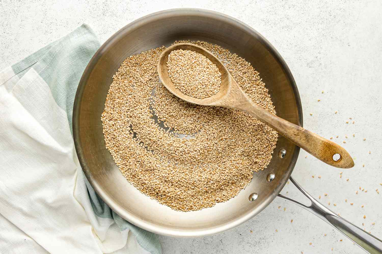 Toasted Sesame Seeds in a Skillet with Some on a Spoon
