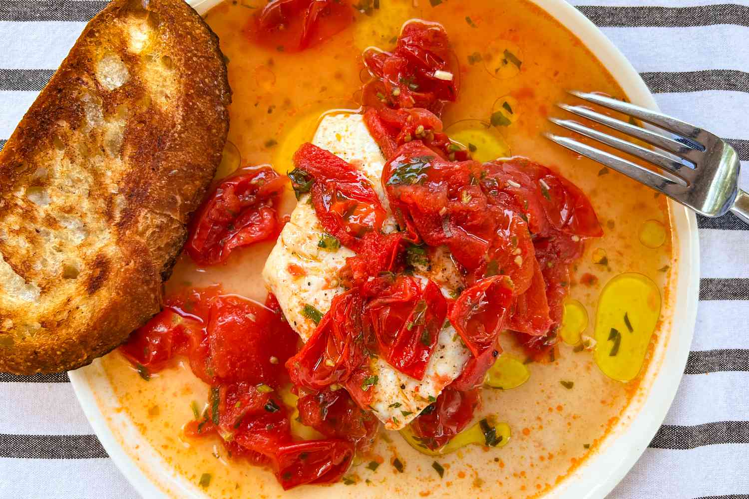 Marcella Hazan’s “Fish in Crazy Water” on a plate with toast and a fork