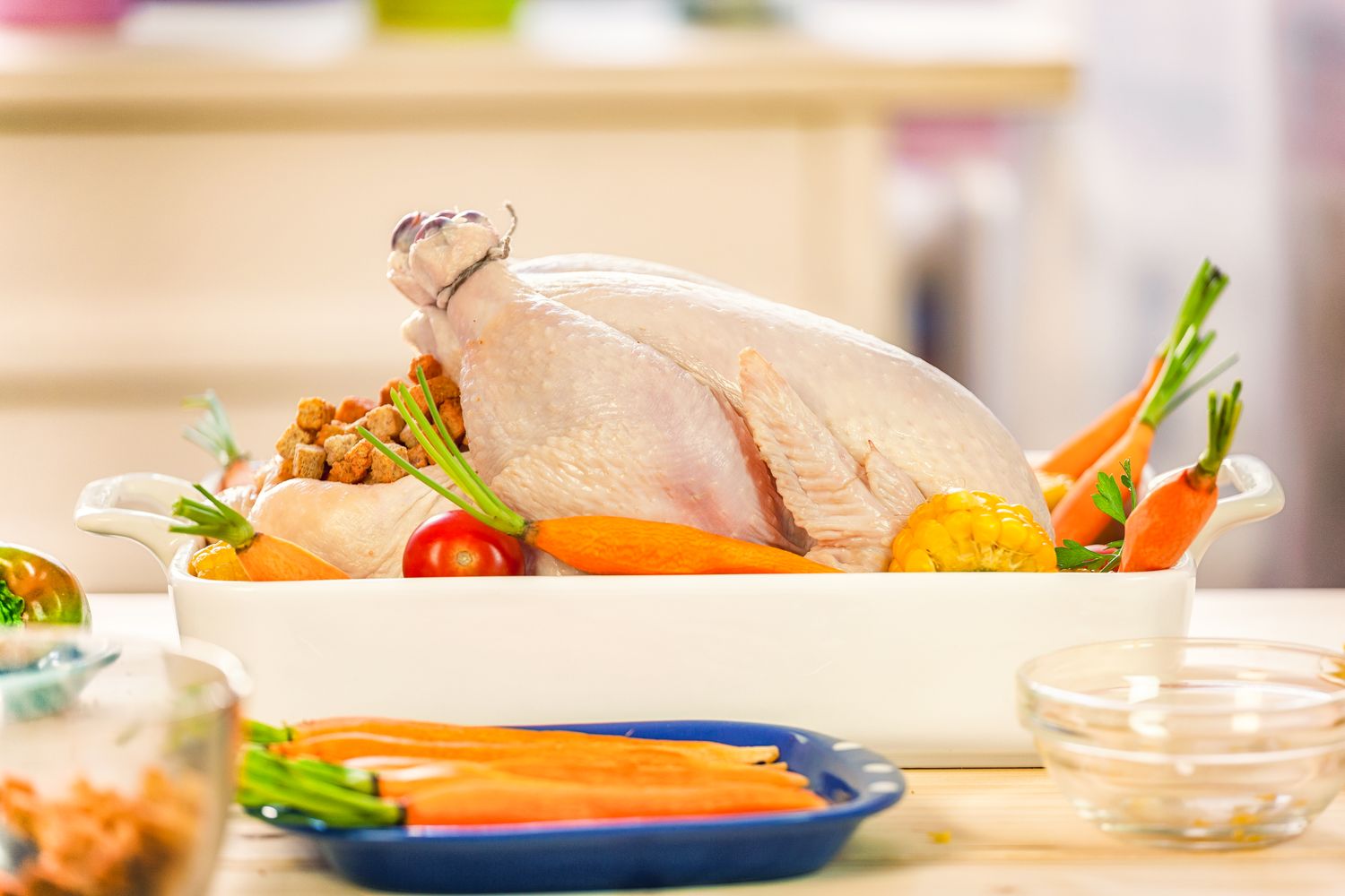 Raw turkey prepared in a dish with vegetables like carrots and squash