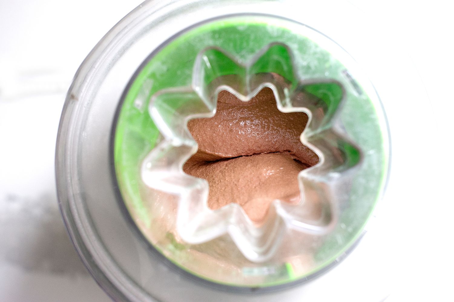 Overhead view of ice cream processed in an ice cream maker for a chocolate ice cream recipe.